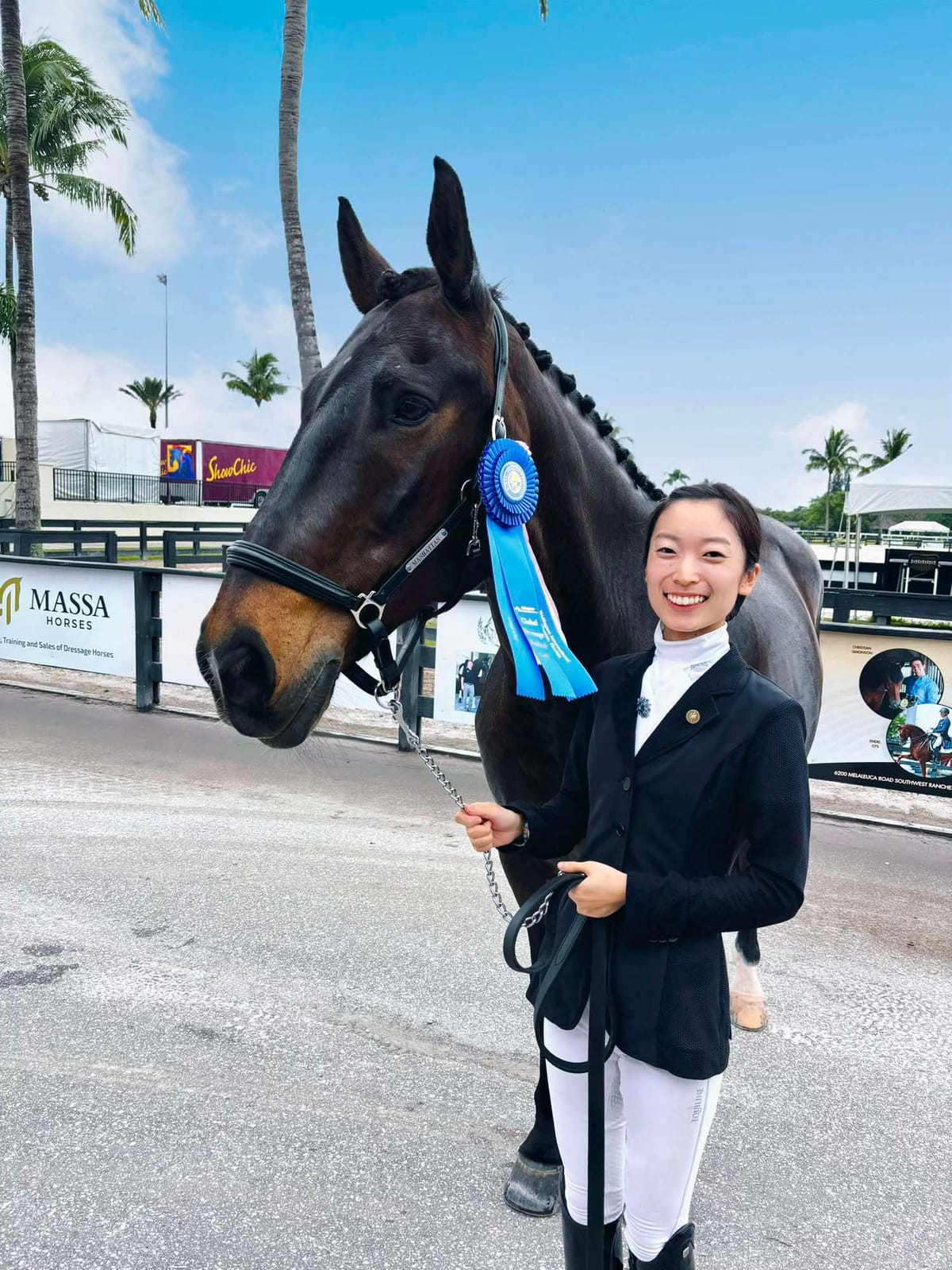 Yuka with a blue ribbon and her horse at a show
